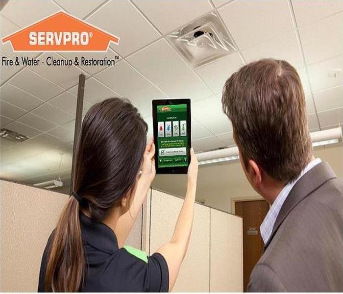 SERVPRO employee showing client the SERVPRO Ready APP on an iPad.